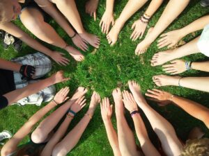 Eine Gruppe von Händen und Füßen, die in verschiedenen Positionen angeordnet sind, symbolisiert die Vielfalt und Komplexität von Beziehungen in der ethischen Nicht-Monogamie.